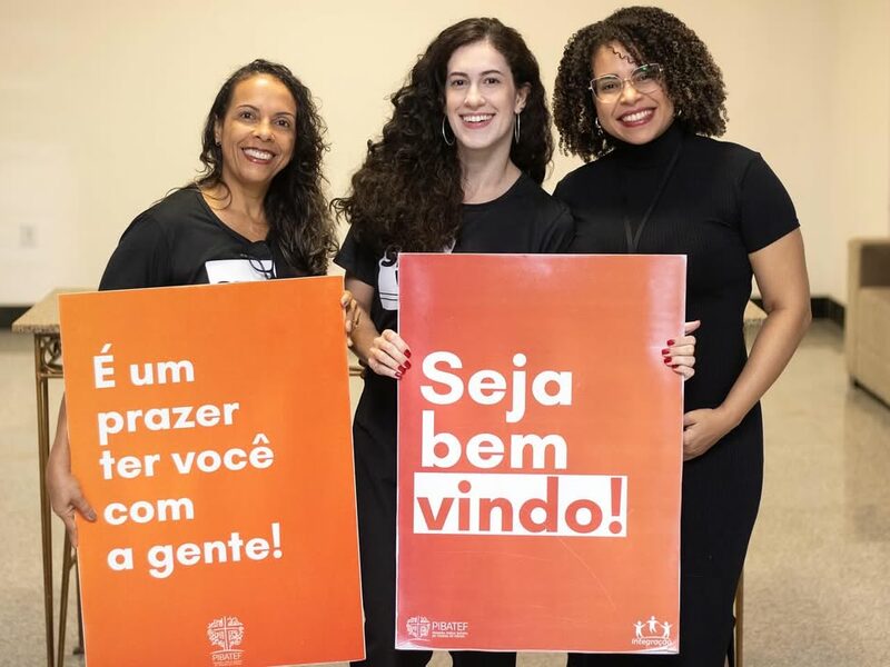 Equipe de integração da PIBATEF segurando placas de boas-vindas